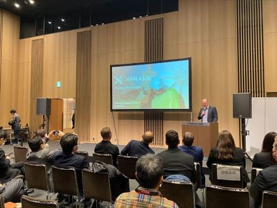 A representative from South Australian company X-Frame speaking behind a podium on stage at the Innovation Leaders' Summit in Japan.
